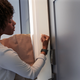 A photo of a person carrying groceries and unlocking their front door with the watch on their wrist